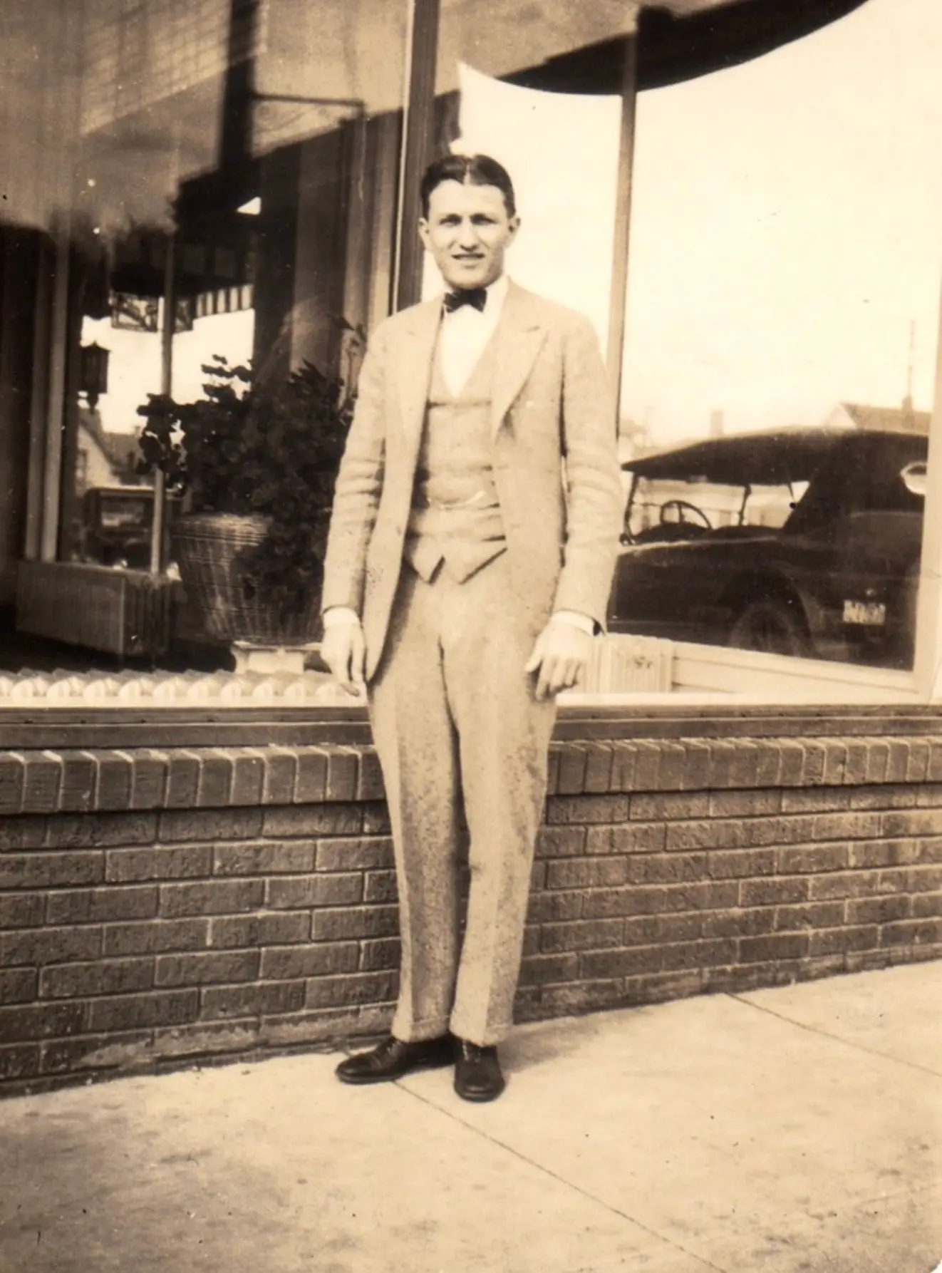 H.H. Fisher in a three-piece suit outside a storefront
