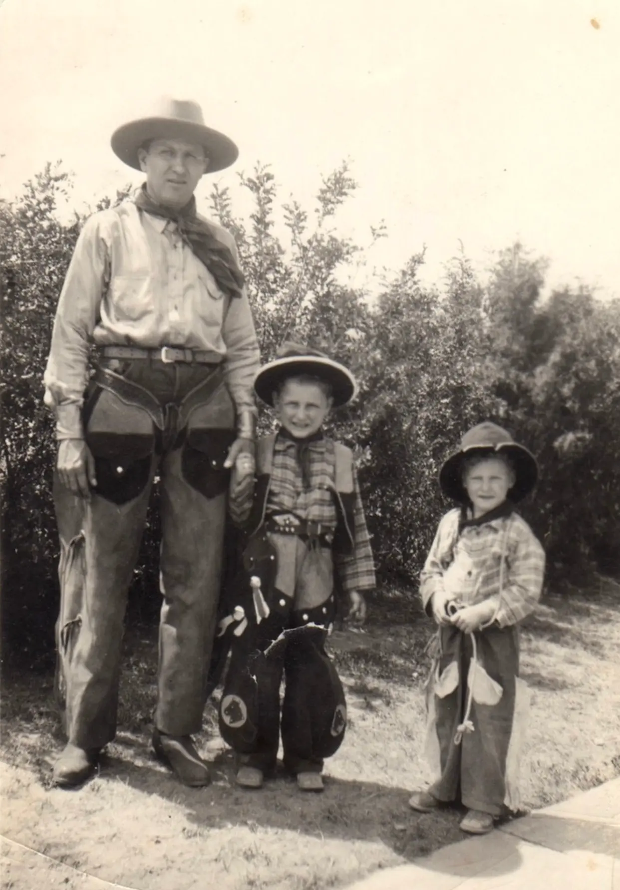 H.H. Fisher with two children in cowboy gear